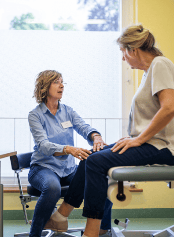 Physio talks to an older female patient
